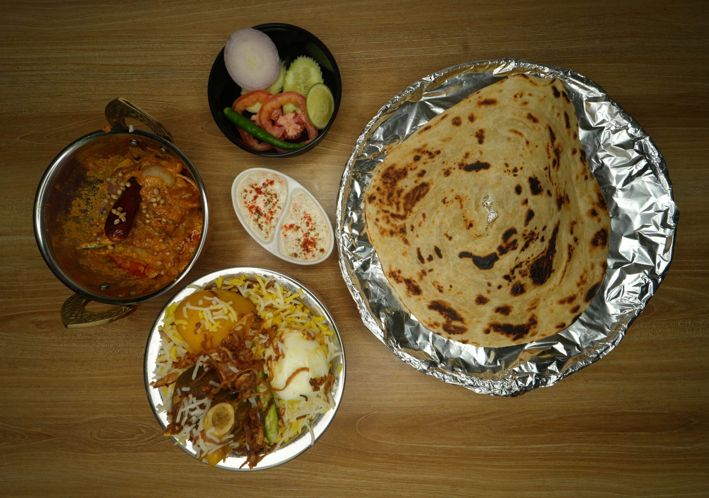 Mutton Biryani+chicken kadhai+lacha paratha+green salad+raita1 (1)